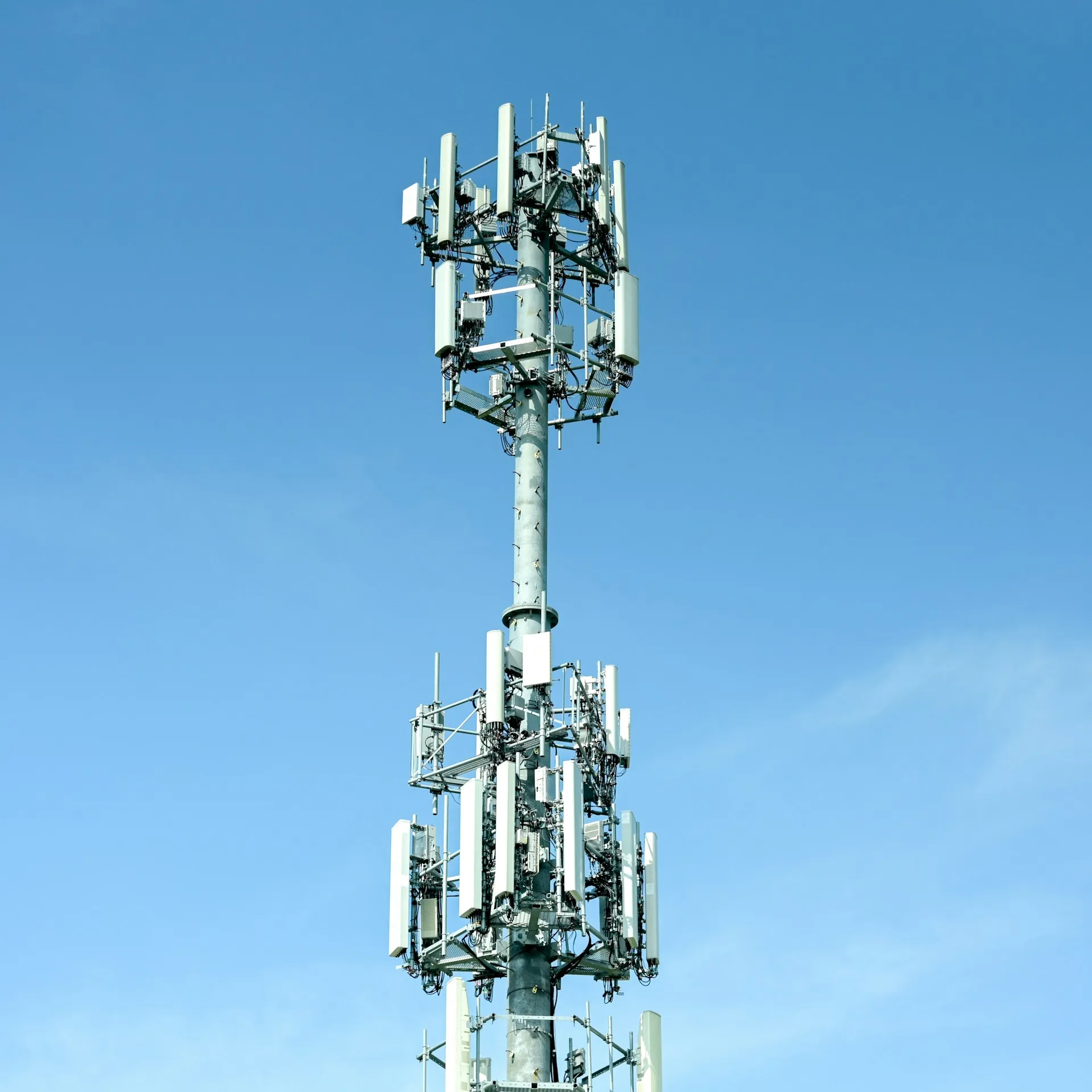 Torre de telecomunicaciones con múltiples arreglos de antenas contra un cielo despejado